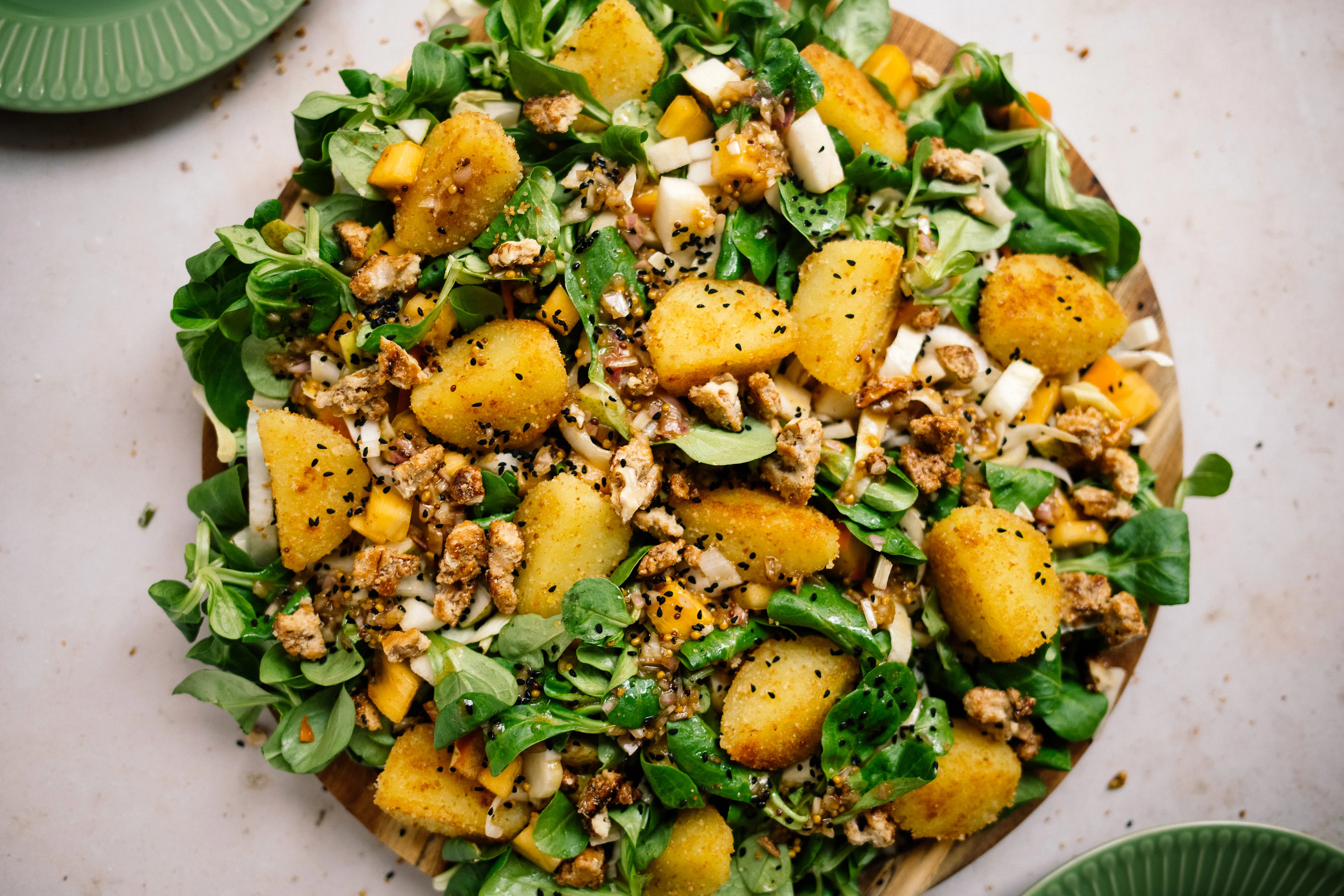 Chi­co­rée-Feldsalat mit Birne, Kaki und Knödel-Croûtons