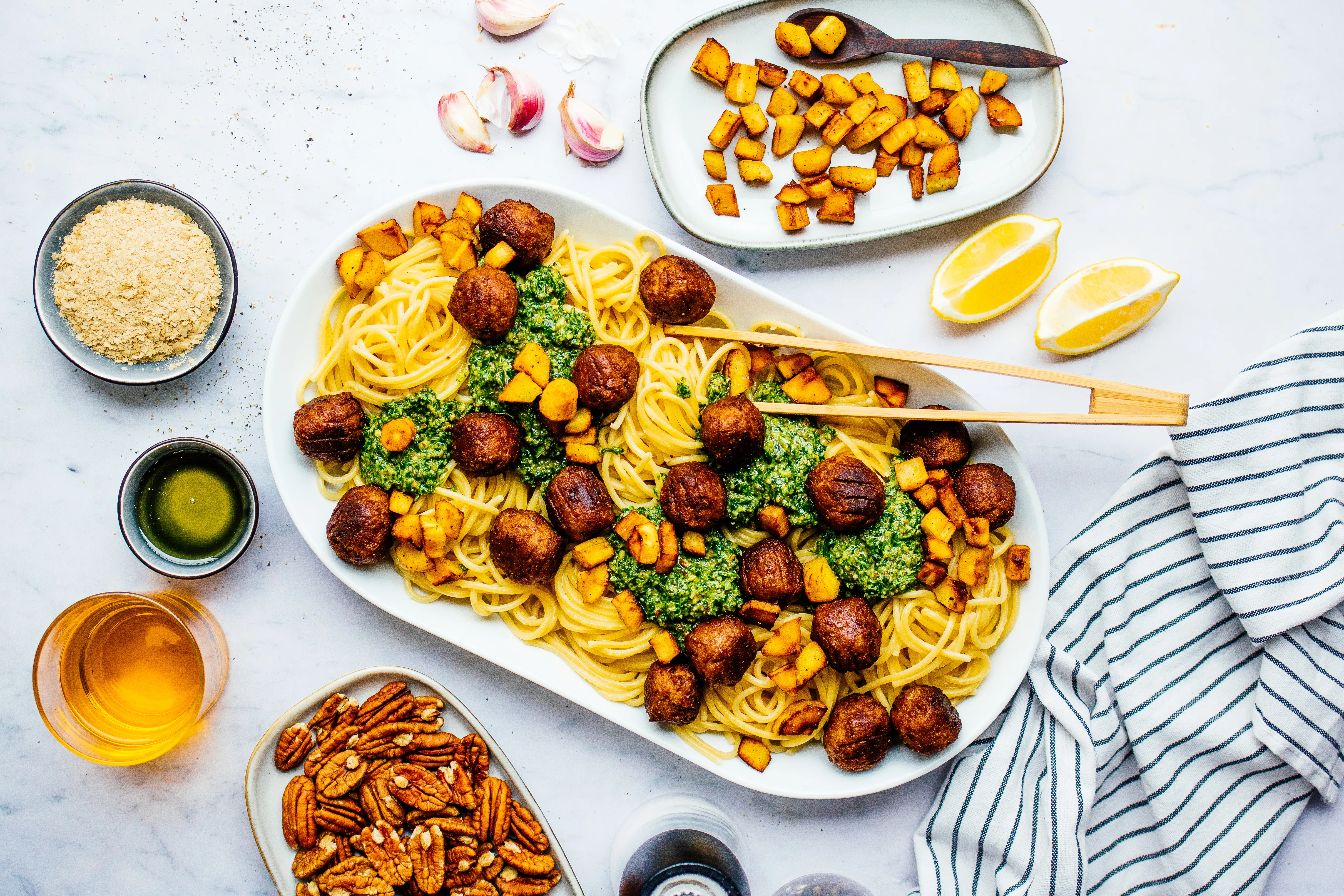 Spaghetti mit Rucola-Pesto, pflanzlichen Bällchen & knusprigen Pastinakenstückchen