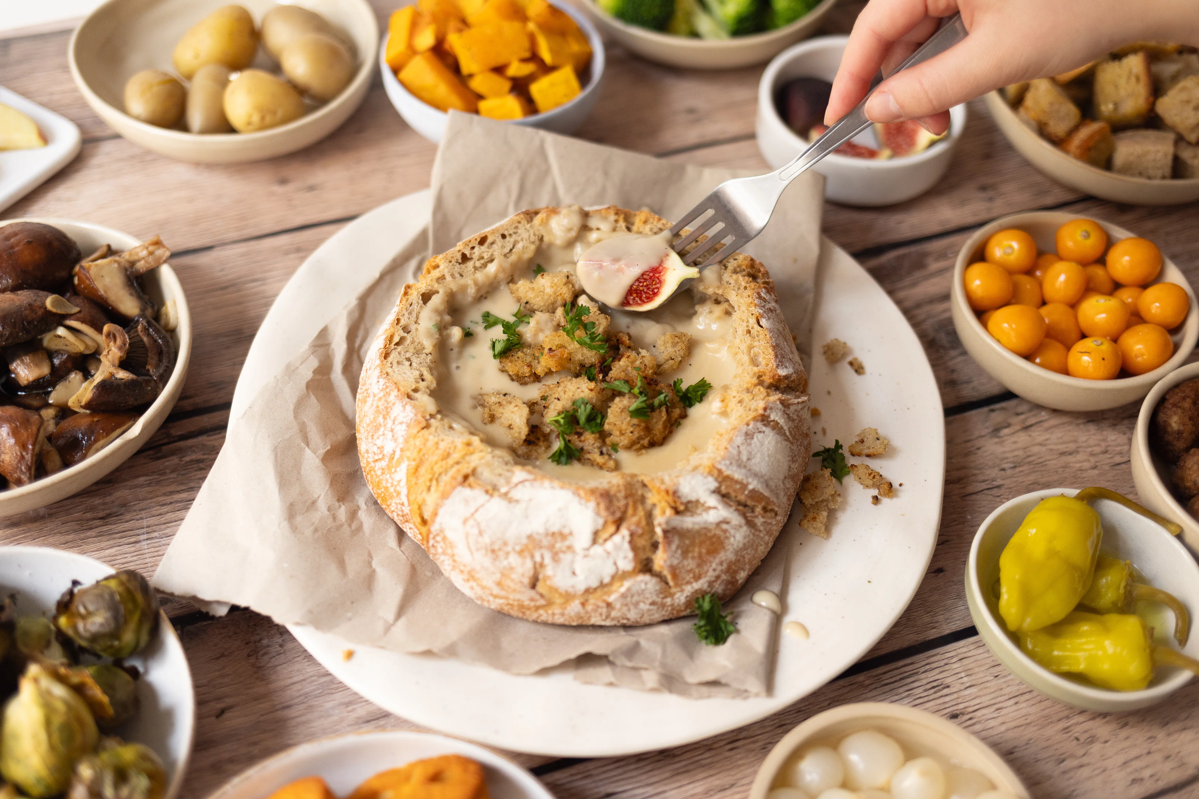 Veganes Käsefondue aus dem Brot mit knusprigem Topping